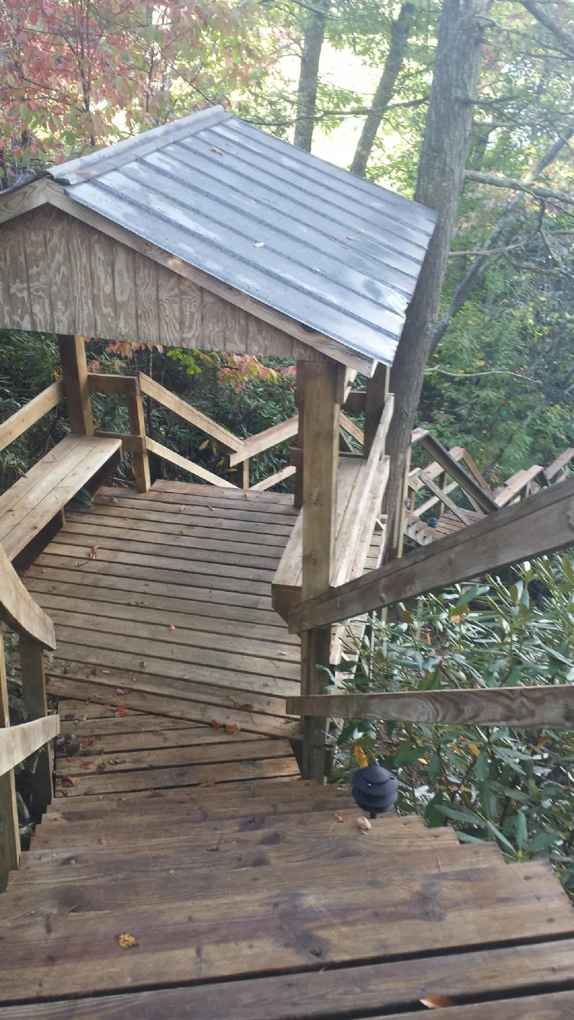 Metal roofed shelter over wooden steps on a wooded walkway — Skylight Repair & Installation work by our crew in Harrison